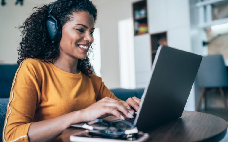 Young modern woman working from home, using laptop in quarantine